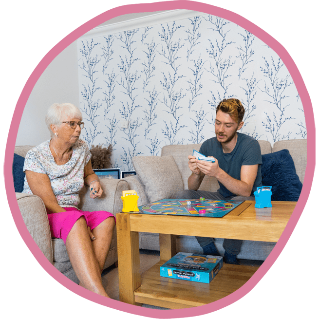 Female client and male carer sat together playing a board game