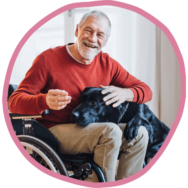 Male client in wheelchair with his black labrador smiling