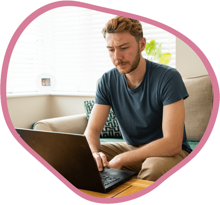 Male carer checking care notes on his work laptop